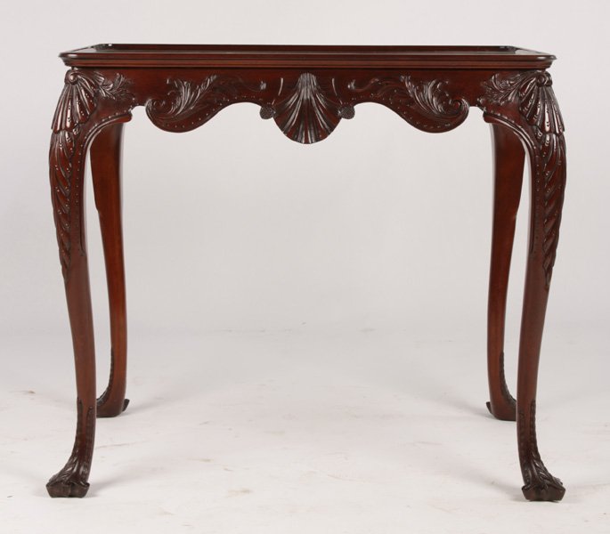 LABELED KINDEL CARVED MAHOGANY DESK TOP TEA TABLE: A good Labeled Kindel Georgian style carved mahogany desk top tea table having shell and foliate carved shaped apron. Branded 'Irish Georgian'. Supported on cabriole legs. Ht: 29" Width: 32.5" Depth: