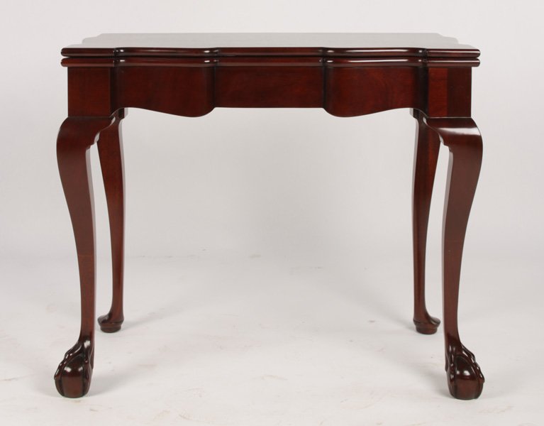 LABELED KINDEL MAHOGANY FLIP TOP GAMES TABLE: A labeled Kindel carved mahogany Chippendale style flip top games table having serpentine apron. Supported on cabriole legs with claw and ball feet. Ht: 28.5" Width: 34" Depth: 18" (Closed)