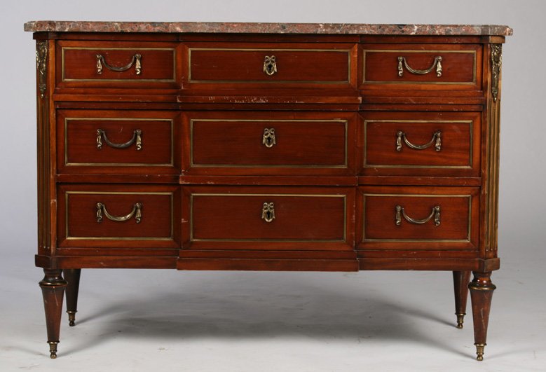 DIRECTOIRE STYLE COMMODE MARBLE TOP: A Directoire style commode having shaped and molded marble top and raised on turned legs with sabots circa 1940. Having three stepped back bronze trimmed drawers flanked by fluted pilasters. Ht: 34" W