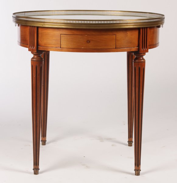 LOUIS XVI STYLE GUERIDON MARBLE TOP BRASS: A Louis XVI style gueridon having marble top with brass gallery over two drawers and two slides, supported on fluted and tapered legs circa 1960. Ht: 29.5" Dia: 29.5"