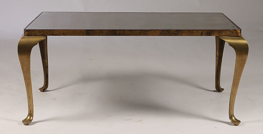 BRONZE COFFEE TABLE MIRRORED INSET TOP CIRCA 1950: A stylized bronze coffee table having distressed mirrored inset top supported on cabriole legs with pad feet circa 1950. Ht: 18" Width: 41.5" Depth: 26"