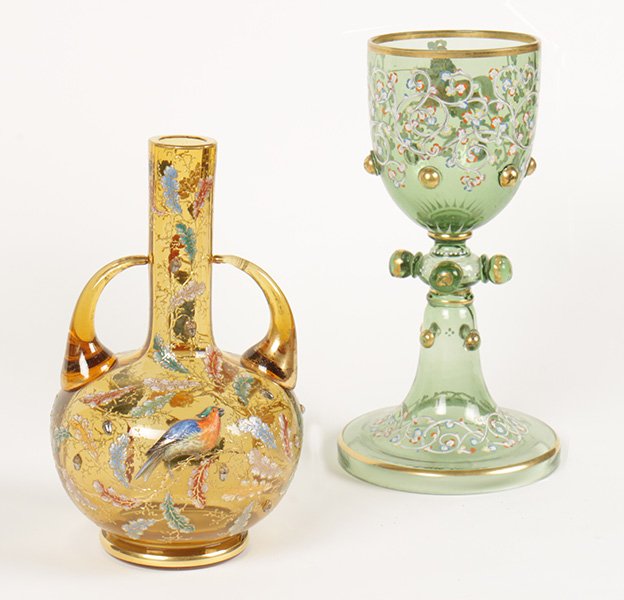 LOT OF 2 GLASS POLYCHROMED VESSELS CIRCA 1890: A group of two glass polychromed vessels circa 1890. Featuring an amber colored two-handled vessel with polychromed bird and foliate decoration signed Moser, and an ornately polychromed chalice having
