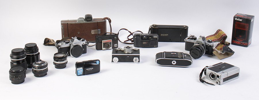 LOT OF 10 VINTAGE CAMERAS: Box lot of ten vintage cameras with some accessory lens and a flash, including two Nikons and a Polaroid land camera model 95.