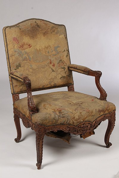 ANTIQUE FRENCH CARVED WALNUT ARMCHAIR NEEDLEPOINT: Antique French carved walnut armchair having needlepoint back and seat with open arms and shaped seat with carved apron raised on cabroile Ht: 43" Width: 28" Depth: 22"