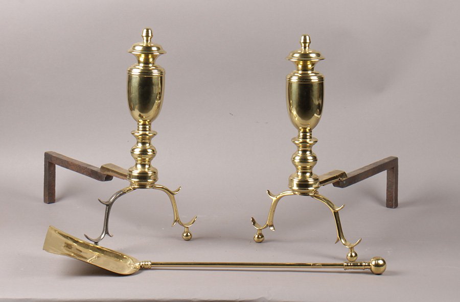 PAIR OF CHIPPENDALE STYLE ANDIRONS WITH SHOVEL: A pair of Chippendale style turned brass andirons along with a single shovel.
