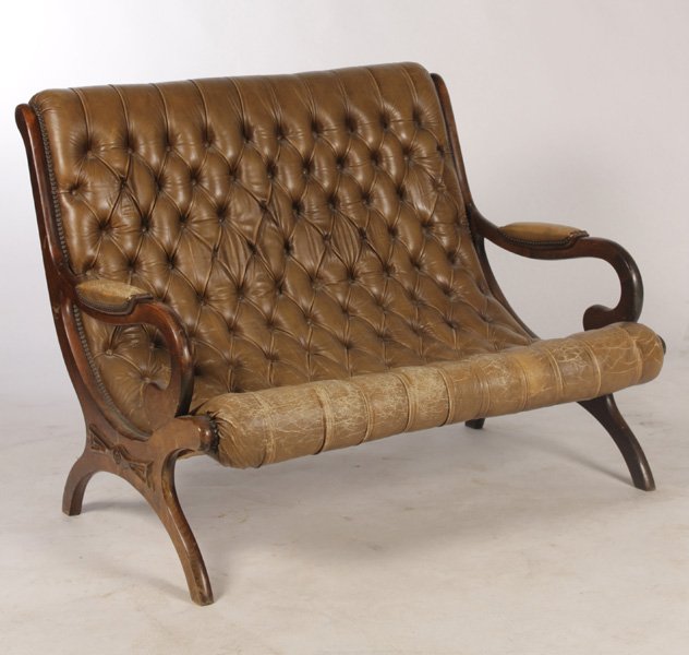 DOUBLE TUFTED LEATHER SETTEE CIRCA 1940: A double tufted leather settee having rolled back and open arms on curule base circa 1940. Dimensions: Ht: 37" Width: 46.5" Depth: 30"
