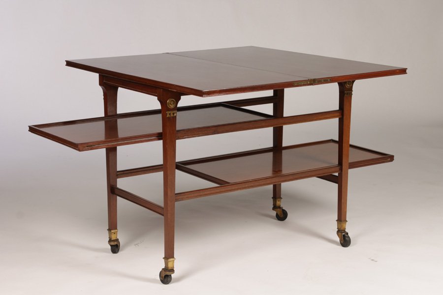 PAIR JANSEN MAHOGANY TEA CART BRONZE MOUNTS: A good Jansen metamorphic mahogany tea cart in the Directoire style having two lower shelves circa 1940. The flip top supported by a base with opposing pull out slides, supported by bronze mounted tap