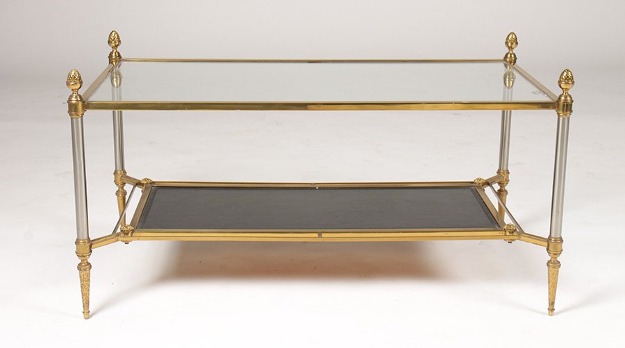 JANSEN 2 TIER BRONZE LEATHER COFFEE TABLE 1950: A Jansen two tiered bronze, chrome, and leather coffee table with glass top, the lower tier having a black tooled leather insert circa 1950. Ht: 19" Width: 36" Depth: 19"