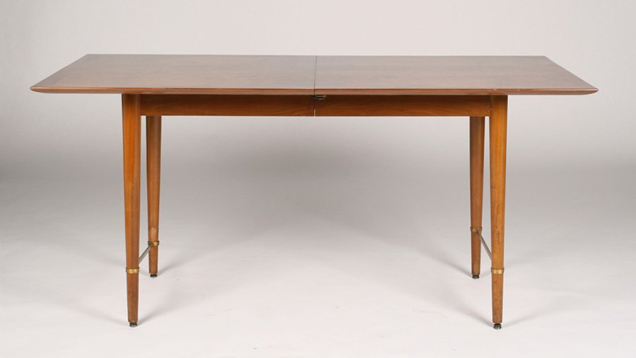 PAUL MCCOBB DINING TABLE ORIGINAL LEAVES: A Paul McCobb dining table having banded top supported on turned and tapered legs with bronze stretcher. With two original leaves. Ht: 39" Width: 61.5" Depth: 32"