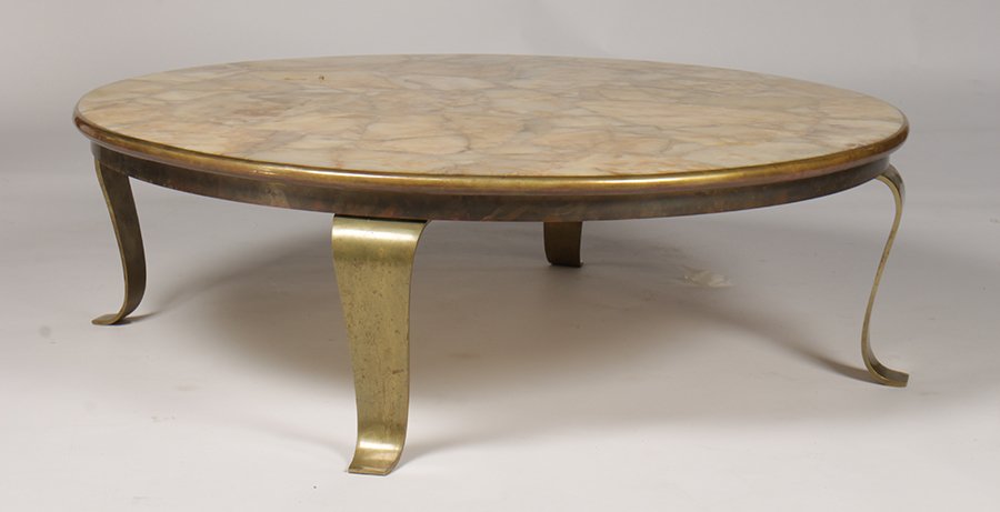MID CENTURY COFFEE TABLE ONYX BRONZE C. 1960: An interesting mid century modern coffee table having an onyx top banded by bronze supported on shaped bronze legs circa 1960. Ht: 15" Dia: 47.75"