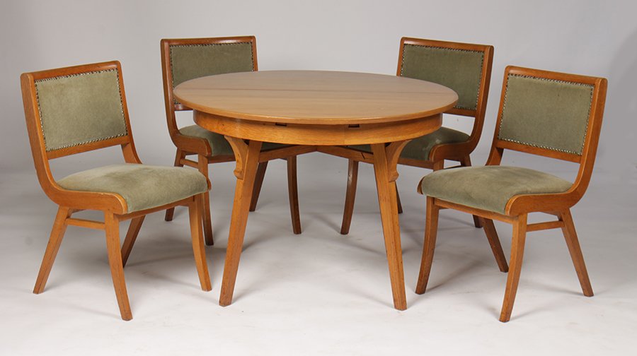 MID CENTURY MODERN DINING TABLE AND CHAIRS C.1950: A mid century modern dining table having a banded top with one middle leaf and six matching chairs with upholstered backs and seats circa 1950. Two arms and two side chairs. Ht: 30" Dia: 43" (table)