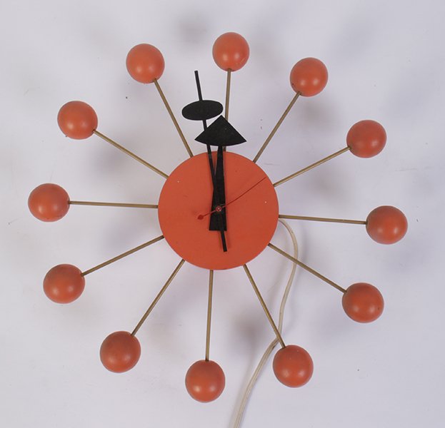 GEORGE NELSON FOR HOWARD MILLER SUNBURST CLOCK: A George Nelson for Howard Miller labeled sunburst clock model # 4755 in orange finish circa 1950. Dia: 13.5"