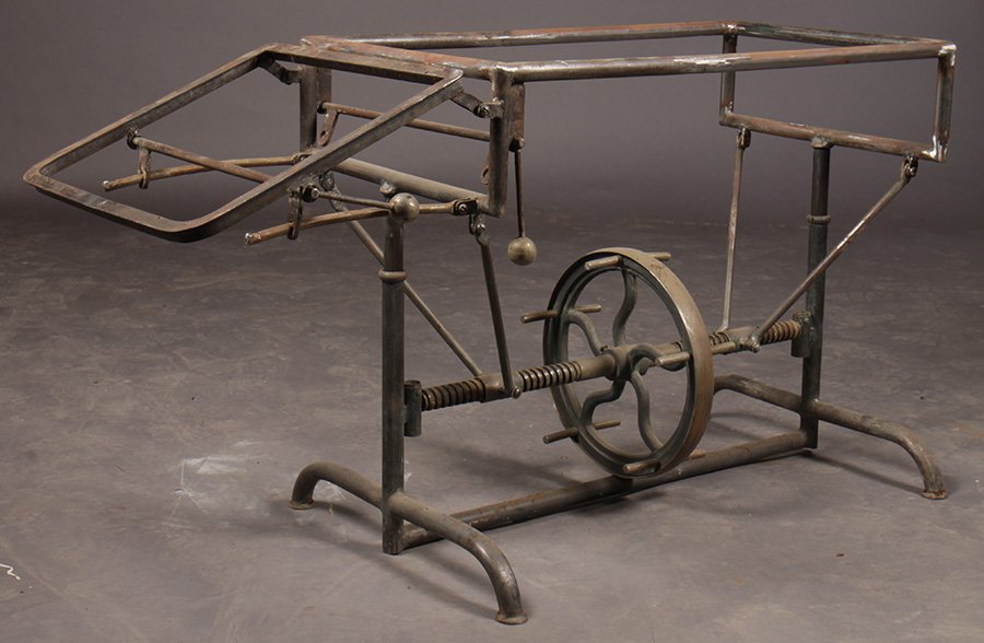 MECHANICAL ADJUSTABLE INDUSTRIAL TABLE FLY WHEEL: A mechanical adjustable industrial table with fly wheel circa 1910. Ht: Adjustable Width: 53" Depth: 19"