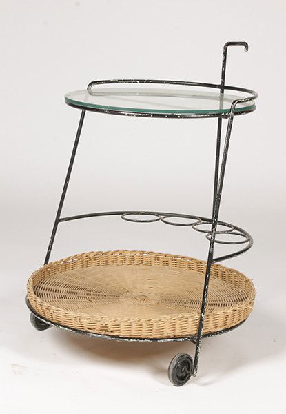 FRENCH MODERN WROUGHT IRON SERVING CART: A French mid century modern wrought iron serving cart having glass shelf over wicker basket tray raised on casters circa 1950. Ht: 31.5" Width: 22" Depth: 23.5"