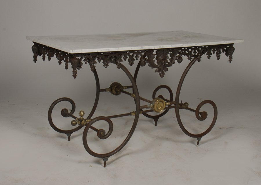 BRONZE IRON BAKERS TABLE MARBLE TOP APRON C.1950: A good bronze and iron baker's table having marble top over open work apron and supported on downswept scrolling legs circa 1950. Ht: 29" Width: 53.5" Depth: 27"