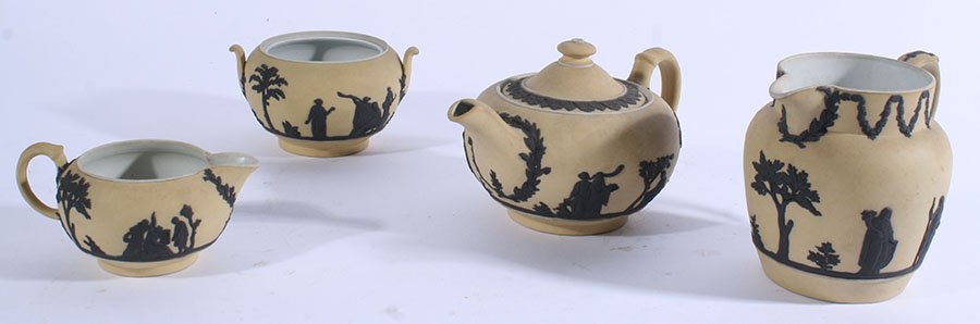 LOT OF 4 WEDGWOOD BLACK YELLOW JASPERWARE C.1930: A four piece collection of Wedgwood black on yellow dip jasperware circa 1930. Consisting of a small teapot, creamer, sugar, and a jug. Ht: 5" (jug)