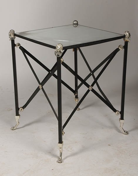 REGENCY WROUGHT IRON SIDE TABLE MIRRORED TOP: A Regency style wrought iron side table having mirrored top and lion head corner mounts over x-form sides raised on paw feet. Ht: 27" Width: 22.5" Depth: 22.5"