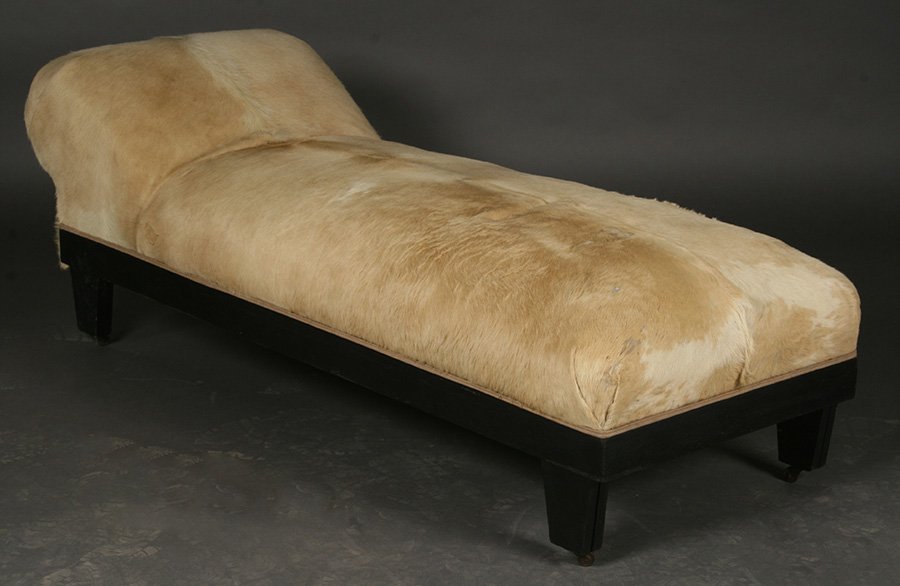 COWHIDE COVERED CHAISE LOUNGE TAPERING LEGS: An interesting cowhide covered chaise lounge with upraised slanted pillow all raised on tapering legs with casters. Ht: 25" Width: 72" Depth: 25.5"