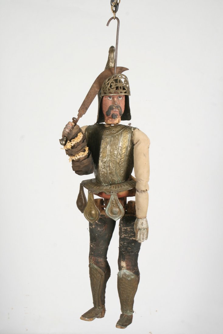 CONTINENTAL CONQUISTADOR WOOD PUPPET 19TH C.: A nineteenth Century Continental conquistador carved wood puppet having tin armor and steel sword with straw body. Ht: 53" Width: 17" Depth: 9"