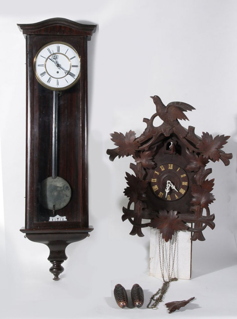 VIENNA REGULATOR AND BLACK FOREST CUCKOO 1910: A grouping of two items to include a Vienna regulator and a Black Forest cuckoo clock circa 1910. Ht: 40" Width: 12" Depth: 6" (largest)