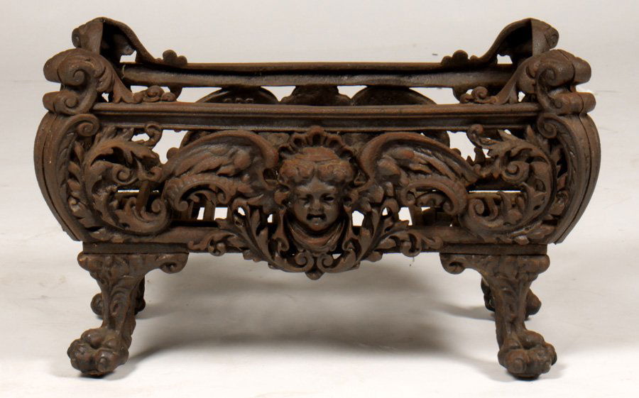 VICT CAST IRON FIREPLACE GRATE PAW FEET 1880: A Victorian cast iron fireplace grate having winged figures flanked by foliate decoration raised on cabriole legs with paw feet circa 1880. Ht: 14.5" Width: 24" Depth: 14"