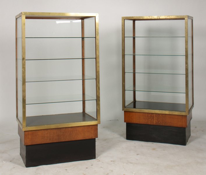 2 BRASS VITRINES W/GLASS PANELED SIDES C.1930: Two brass vitrines having glass paneled sides and oak plinth bases circa 1930. Ht: 60" Width: 43" Depth: 21"