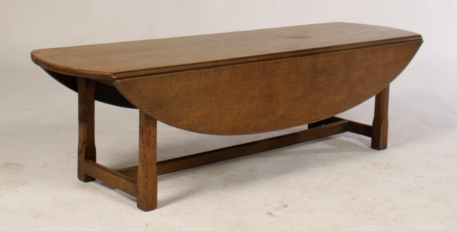ENGLISH OAK DROP SIDE OVAL COFFEE TABLE: An English oak drop side oval coffee table. Ht: 17" Width: 60" Depth: 35.5"