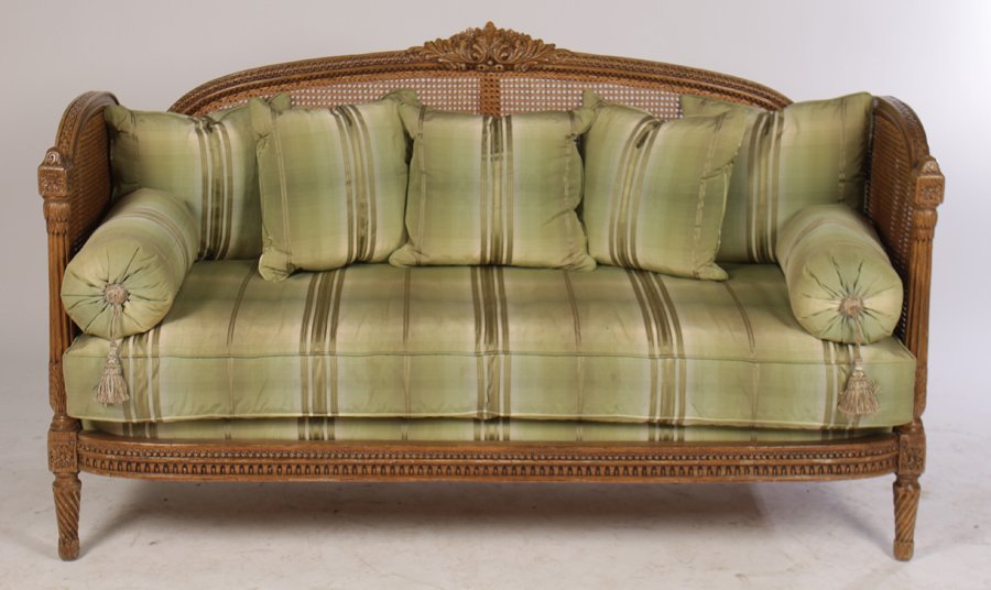 LOUIS XVI DAYBED CANED UPHOLSTERED MATTRESS 1920: A Louis XVI style daybed having central carved cartouche over caned back and arms with fluted column front supports circa 1920. Over an upholstered mattress with multiple pillows. All raised on twist 