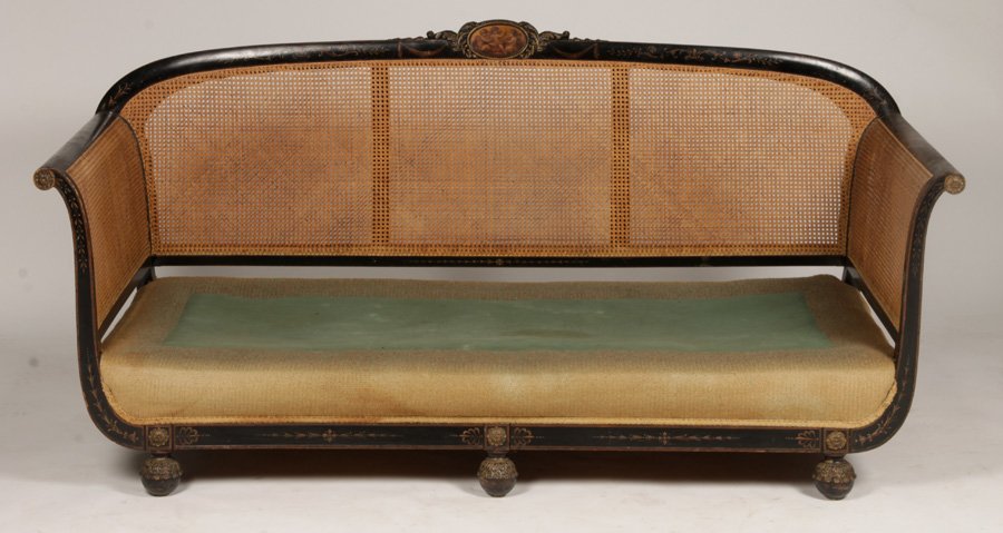 19TH C. ADAMS STYLE PAINTED & CANED SOFA: A nineteenth century Adams style painted and caned sofa having central figural medallion flanked by draped garland over upholstered seat. Raised on turned feet. Lacking cushion. Ht: 35" Width: 74" Dep