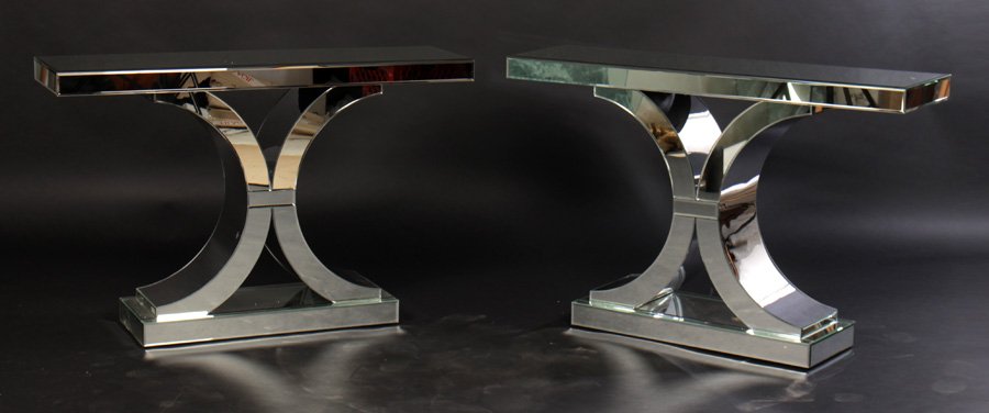 PAIR MIRRORED HOLLYWOOD REGENCY CONSOLE TABLES: A pair of mirrored Hollywood Regency style console tables in the manner of Serge Roch. Finished on both sides. Dimensions: Ht: 30" Width: 46" Depth: 13.25"