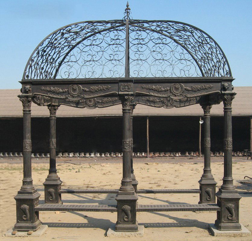 CAST IRON GAZEBO WROUGHT IRON DOME BENCH SEATS: A monumental cast iron gazebo having wrought iron dome supported on fluted columns with capital tops and bench seats. Ht: 14' Width: 9' Depth: 13'