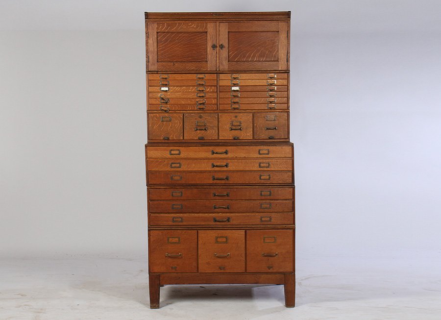 SHAW WALKER OAK STACKING CABINET 1900: A good labeled 'Shaw Walker' oak stacking cabinet having paneled doors over a set of collectors and filing drawers circa 1900. All resting on stepped base with three sections of drawers, raised on tap