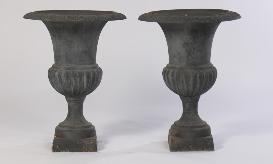 PAIR CAMPANA FORM CAST IRON GARDEN URNS: A pair of campana form cast iron garden urns having egg and dart rim and melon form bowl raised on stepped base. Ht: 29" Dia: 20"