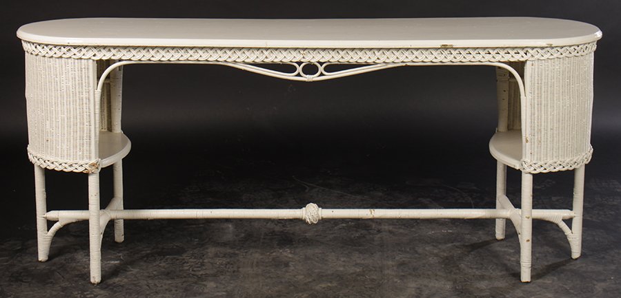 EARLY 20TH C. WICKER SOFA TABLE W/ SHELF C.1930: An early twentieth century wicker sofa table having oval top over woven apron and closed ends with interior shelf circa 1930. Ht: 30" Width: 69.5" Depth: 18.5"