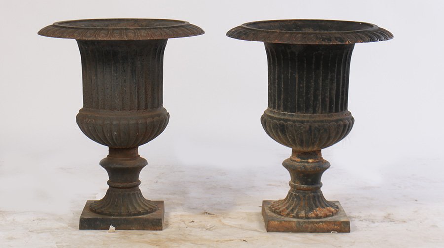 PAIR CAST IRON CAMPANA FORM GARDEN URNS: A pair of cast iron campana form garden urns having egg and dart rim over fluted body and raised on stepped base. Provenance: Removed from a Main Line, PA estate. Ht: 27" Dia: 20"
