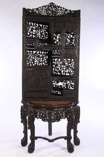 CARVED CHINESE HARDWOOD CORNER CABINET 1870: A profusely carved nineteenth century Chinese hardwood corner cabinet circa 1870. The top having two sliding doors, two small drawers, and two doors. The whole resting on a marble top figural carved b