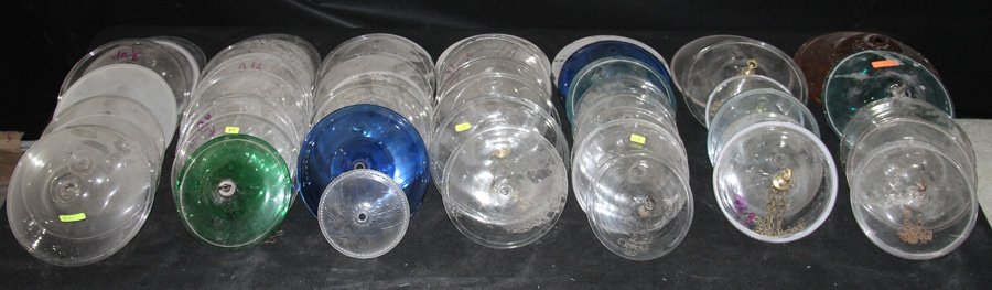 48 BRITISH COLONIAL STYLE GLASS LIDS CIRCA 1950: A collection of forty eight British Colonial style glass lids of a variety of shapes and colors circa 1950. Ht: 13" Wd: 7"