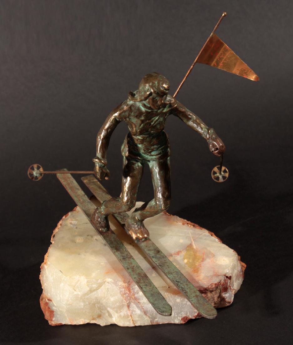 LABELED CURTIS JERE BRONZE FIGURE CIRCA 1970: A labeled Curtis Jere bronze figure of a skier mounted on natural alabaster base circa 1970. Ht: 9" Wd: 7" Dpth: 10"