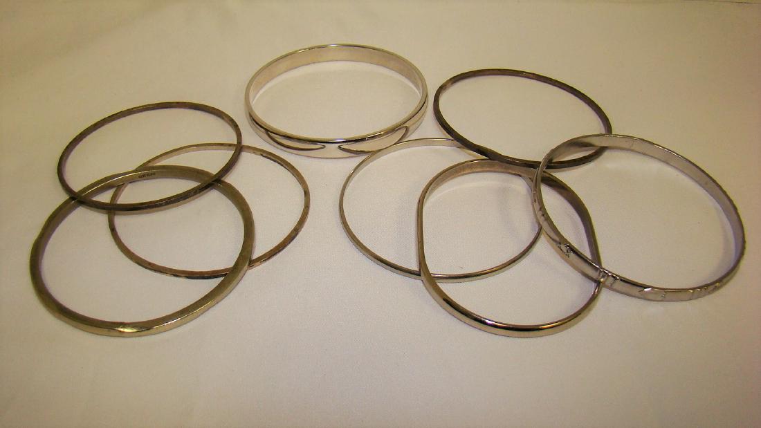 SILVER AND STERLING BANGLE BRACELETS - UNMARKED: SILVER BANGLE BRACELETS - UNMARKED-BELIEVED TO BE MOSTLY STERLING - ONE WITH STAMPED ARROW DESIGN - ONE MARKED MONET - 8 IN TOTAL