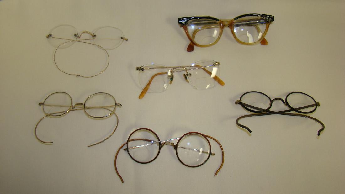 6 PAIRS OF VINTAGE EYE GLASSES: 6 PAIRS OF VINTAGE EYE GLASSES - 2 PAIR OF WIRE RIMMED ROUND LENSE EYEGLASSES IN GOLD AND RED COLORED METAL - 1 PAIR OF BLACK WIRE RIMMED BI-FOCAL GLASSES - 1 PAIR OF RIMLESS WIRE ROUND GLASSES - 1 PA