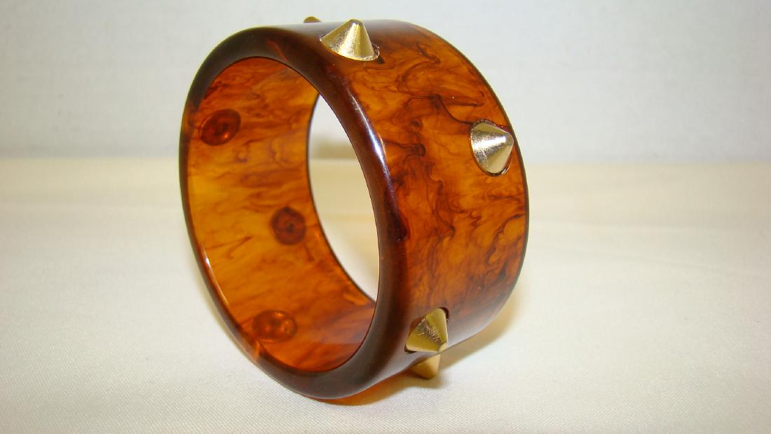 VINTAGE TORTOISE SHELL BAKELITE BRACELET: VINTAGE TORTOISE SHELL COLORED BAKELITE BRACELET WITH GOLD TONED STUDS IMBEDDED - 1 & 1/2 WIDE
