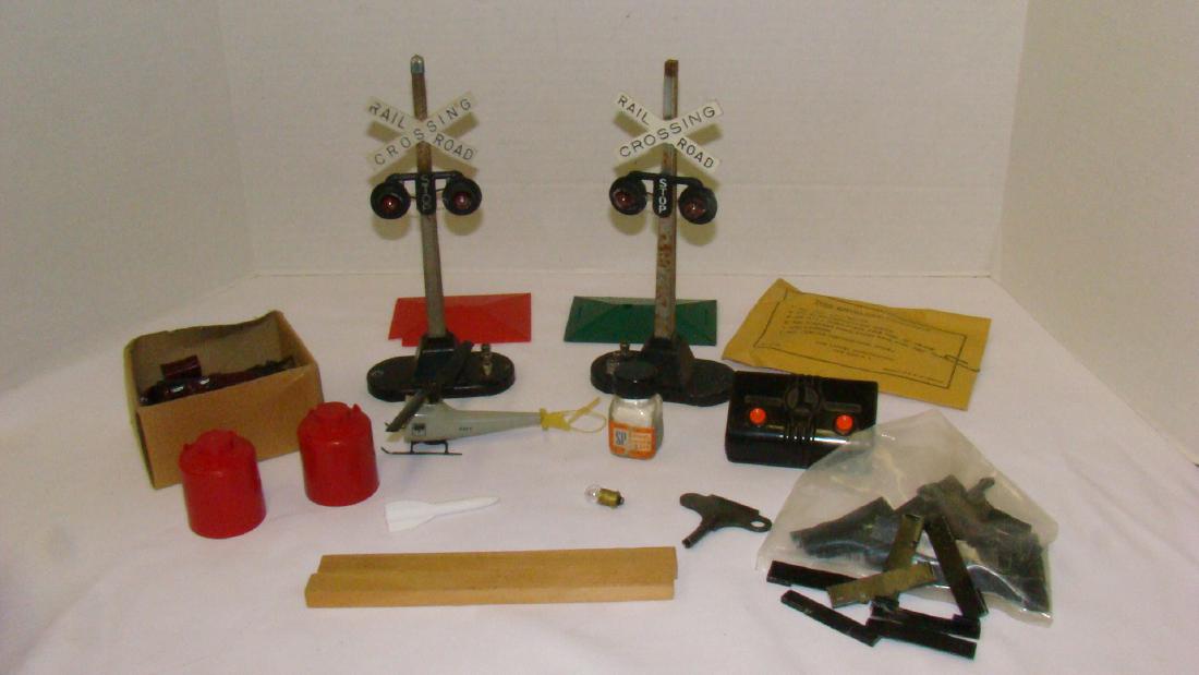LIONEL RAILROAD CROSSING SIGNS-SMOKE PELLETS & MOR: LIONEL RAILROAD CROSSING SIGNS-SMOKE PELLETS & MORE - 2 RED CYLINDERS - PARTIAL NAVY HELICOPTER- TWO WOOD PLANKS - ROCKET & MORE