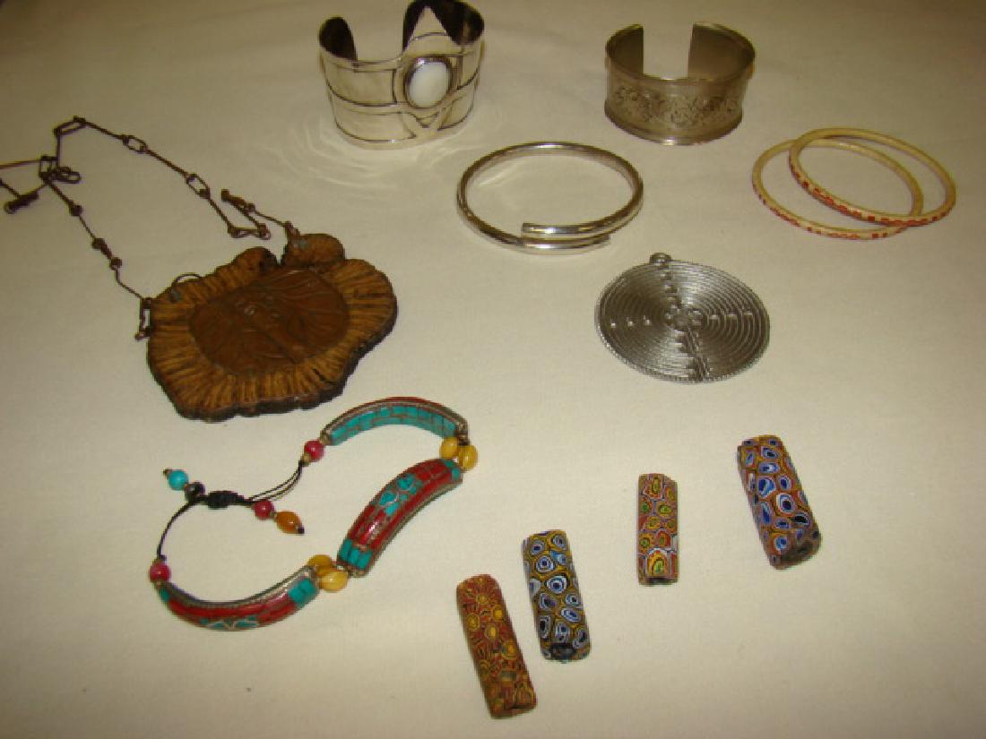 TRAY VARIOUS UNIQUE BRACELETS-BEADS AND PENDANTS: WONDER WOMEN STYLE CUFF BRACELET-ENGRAVED METAL CUFF BRACELET-3 VARIOUS BANGLE BRACELETS-CLOISONNE LINK BRACELET- 4 LARGE POTTERY BEADS- ROUND ENGRAVED METAL PENDANT AND A CARVED WOOD NECKLACE