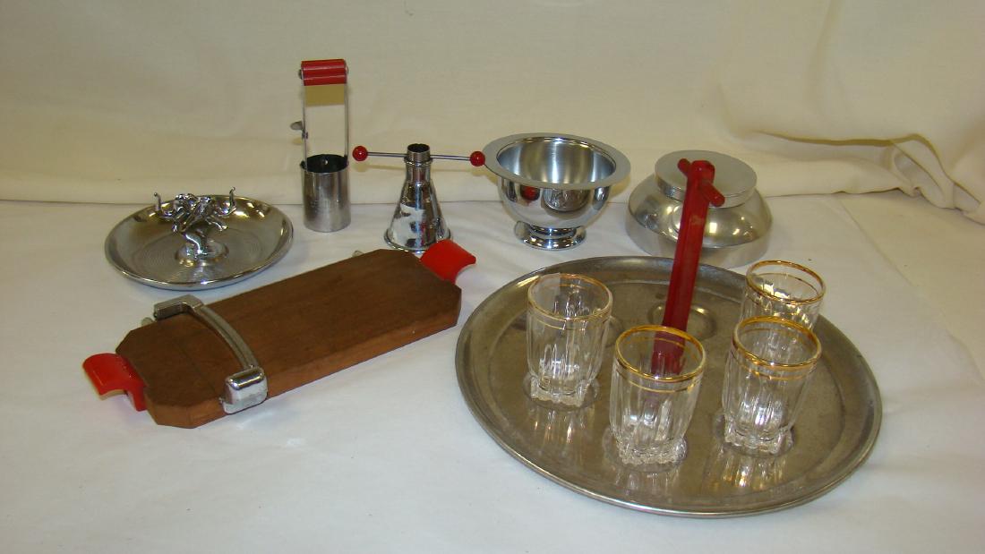 CHROME & BAKELITE BAR WARE: CHROME & BAKELITE BAR WARE - SHOT GLASS CADDY WITH RED BAKELITE HANDLE- MISSING 2 SHOT GLASSES - CHROME CIGARETTE HOLDER WITH ELEPHANT DESIGN - CHEESE CUTTER WITH RED BAKELITE HANDLES & MORE