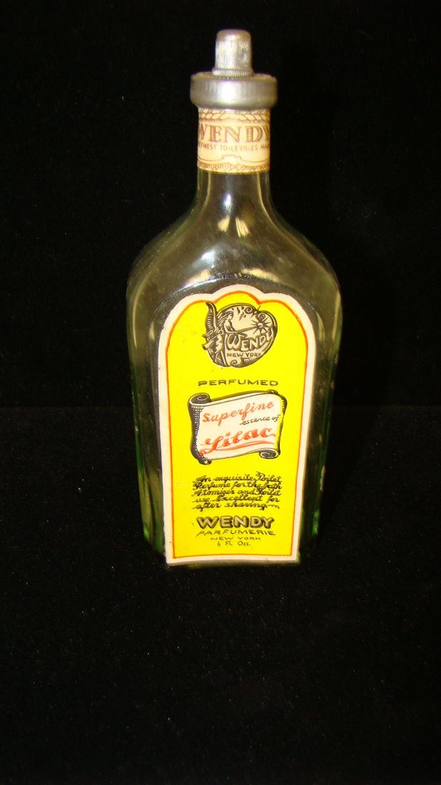 VINTAGE ''WENDY'' PERFUMED BOTTLE 6OZ, ESSENCE OF LILAC: VINTAGE ''WANDY'' PERFUMED BOTTLE 6OZ, ESSENCE OF LILAC. NICE OLD BOTTLE FROM ''WENDY PARFUMERIE, NEW YORK'' 6 FL. OZS. BOTTLE HEALD SUPER FINE ESSENCE OF LILAC, STILL HAS METAL CAP ON TOP.