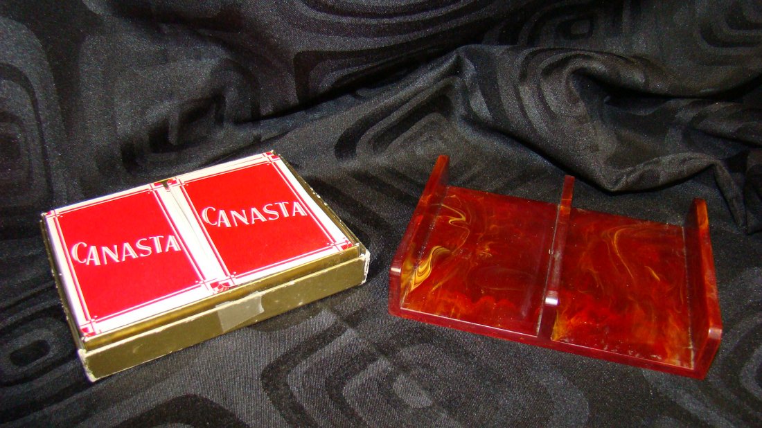 BAKELITE DBL DECK CARD HOLDER-CANASTA CARDS: MARBLED WINE AND YELLOW COLOR BAKELITE DOUBLE DECK CARD HOLDER AND A DOUBLE DECK CANASTA CARD SET IN ORIGINAL BOX AND A LEATHER DICE CUP WITH 2 SMALL AND 2 LARGE DICE