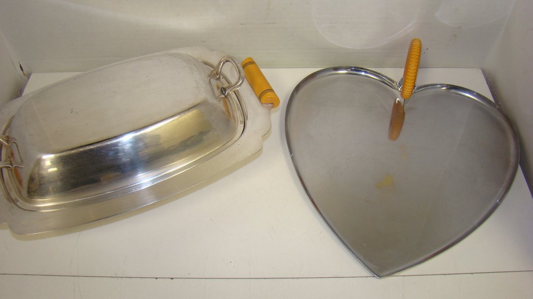 HEART SHAPED TRAY & COVERED BOWL-BAKELITE HANDLES: CHASE HEART SHAPED CHROME TRAY WITH AMBER BAKELITE HANDLE - APPROX 11''x 10'' - 3'' ROUND BAKELITE HANDLE - SOME MINOR FINISH LOSS IN CENTER OF TRAY - 12.5'' METAL COVERED SERVING DISH - AMBER BAKELIT