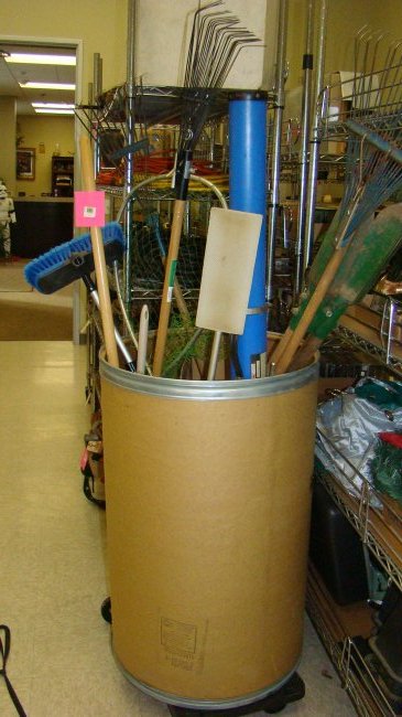 LARGE BARREL OF LONG HANDLE TOOLS: LARGE BARREL LOT OF VARIOUS LONG HANDLE GARDEN TOOLS - FISHING ROD TUBE - BROOMS - T-SQUARES - FISHING NET - AXES - SWIFTER - RAKES AND MORE - BUYER RESPONSIBLE FOR MAKING SHIPPING ARRANGEMENTS