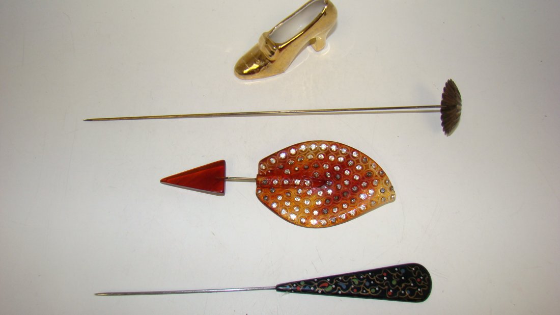 3 VINTAGE HAT PINS & PORCELAIN SHOE: VINTAGE FLUTED METAL HAT PIN 9.5'' - VINTAGE TORTOISE SHELL COLOR WITH RHINESTONE STUDS (MISSING SOME STONES) - 5.5'' - A HAND PAINTED BLACK CELLULOID HAT PIN - 7'' AND A SMALL GOLD COLOR PORCELAIN SH