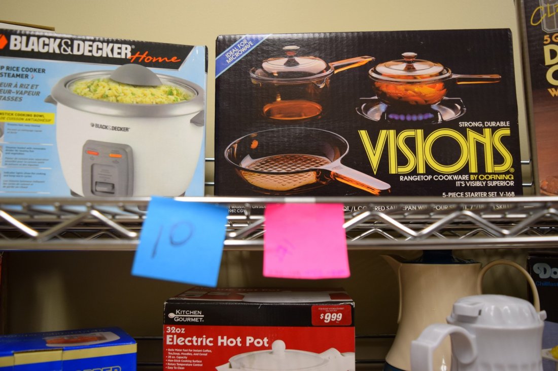 SHELF-NIB KITCHEN ITEMS: SHELF LOT - VARIOUS NIB KITCHEN ITEMS - CAST IRON DUTCH OVEN - VISIONS RANGETOP COOKWARE - BLACK AND DECKER RICE COOKER - NON-STICK WOK AND MINI FOOD CHOPPER